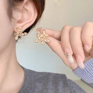 Gros plan détaillé de boucles d'oreilles fleurs en zircon et perles portées