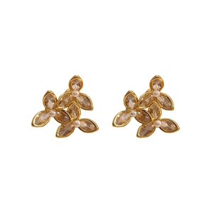 Détail de boucles d'oreilles fleurs avec pétales en zircon et petites perles