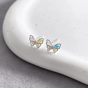 Macro view of mini silver butterfly earrings with colorful cubic zirconia stones
