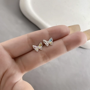 Macro view of mini silver butterfly earrings with colorful inlaid cubic zirconia stones