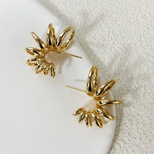 Detailed view of radial gold-plated earrings with a geometric sunburst design and mirror finish