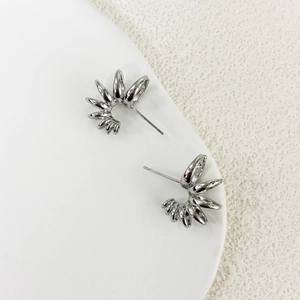 Macro detail of silver radial multi-loop stud earrings with 3D gradient geometry