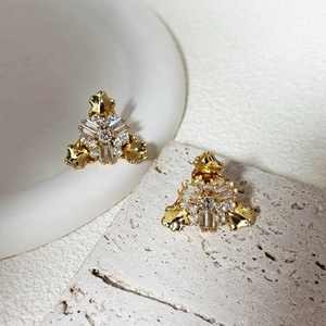 Detailed view of geometric zircon stud earrings with gold-plated lava texture on stone base