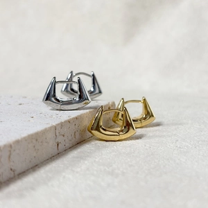 Macro shot of geometric square hoop earrings in gold and silver finish with high-gloss polish