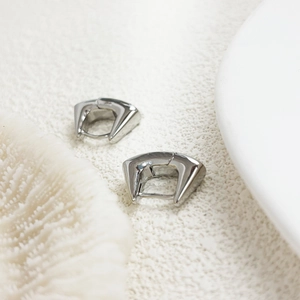 Polished 18K gold plated U-shaped geometric earrings on a textured stone surface