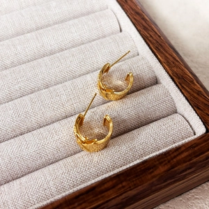 Boucles d'oreilles C dorées à l'or 18K avec texture en relief dans un écrin