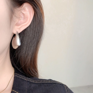 Silver drop earrings with textured pebble finish and modern geometric hollow design