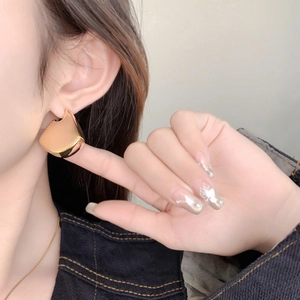 Modern hollow geometric rose gold earrings with mirror finish worn by a model