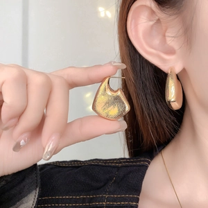 Detail of high-quality gold plated irregular hollow C-shaped geometric hoop earrings