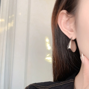 Detailed view of silver teardrop geometric earrings with a high-polished mirror finish