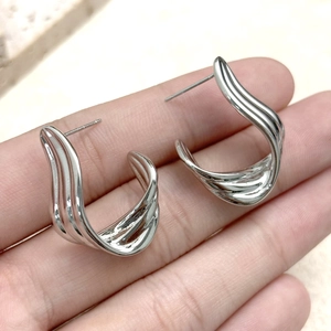 Close-up of S925 sterling silver ribbon earrings with high-polished liquid metal finish