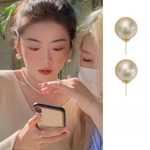 Detail of vintage round cotton pearl earrings with unique crinkled texture on gold studs