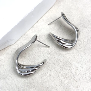 Macro shot of S925 sterling silver ribbon earrings with polished wavy design and stamp