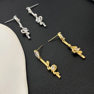 Elegant 18K gold plated snake stud earrings with zircon inlay on black leather background