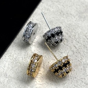 Dettaglio macro degli orecchini a perno placcati oro 18K con zirconi bianchi e neri