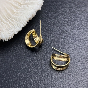 Polished 18K gold plated twisted double C hollow hoop earrings on black leather base