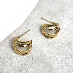 Detail of 18K gold-plated double C-shaped stud earrings with polished mirror finish