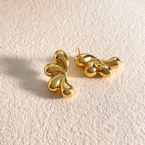 Detalle de pendientes dorados de gota con baño de oro 18K mostrando el cierre posterior