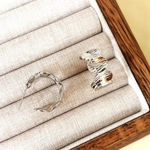 Modern geometric C-shaped hoop earrings with textured finish in elegant jewelry display box