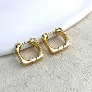 Dettaglio di orecchini a cerchio quadrati in oro lucido dal design geometrico