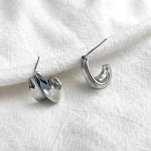 Chic silver irregular crescent stud earrings in S925 sterling silver on fabric