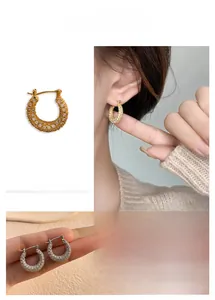 Detailed views of gold and silver C-shaped hoop earrings with pave-set zircon crystals