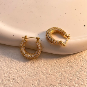 Detail of gold-plated hoop earrings featuring micro-pave set sparkling cubic zirconia stones