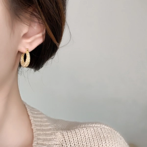 Close-up of gold-plated hoop earring with micro-pave cubic zirconia on female model