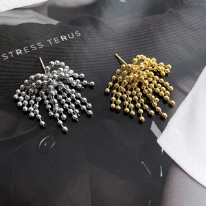 Vue macro de boucles d'oreilles à pampilles dorées et argentées sur un magazine