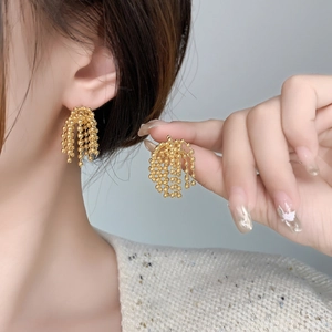 Macro des boucles d'oreilles pompons perlées plaquées or 18K avec détails en éventail