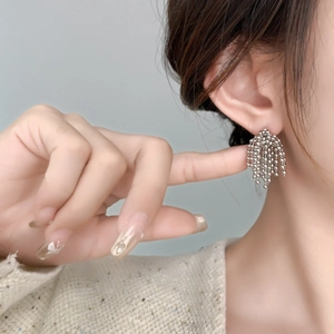 Gros plan de boucles d'oreilles à franges argentées avec perles élégantes sur un modèle