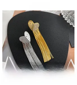 Detail shot of elegant heart tassel earrings with micro-inlaid rhinestones on a black pad