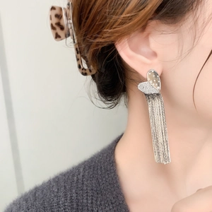 Elegant silver heart chain tassel earrings with sparkling crystals worn by a model