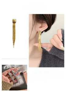 Detail view of long tassel chain earrings in gold and silver finish on model