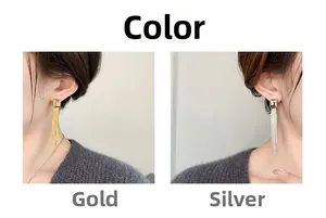 Close-up of long metal tassel earrings in gold and silver showing the geometric square design