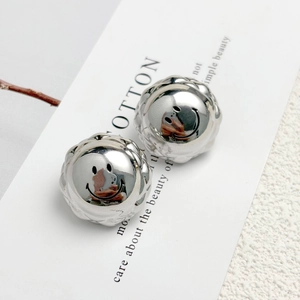 Polished silver smile face sphere earrings with wave relief texture on white background
