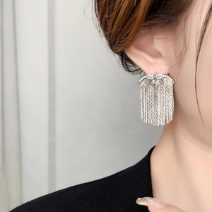 Detail of silver long fringe earrings with pavé setting and 18K gold-plated chains