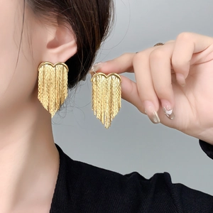 Detail of 18K gold-plated tassel earrings with heart motif and wheat chain fringe