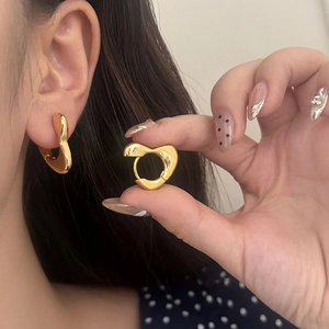 Boucles d'oreilles cœur minimalistes plaquées or 18 carats avec finition polie sur modèle