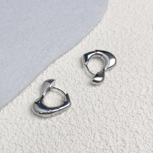Vue détaillée des boucles d'oreilles cœur dorées 18K avec un design en métal liquide