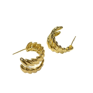 Minimalist gold oval twist C-shaped stud earrings with polished spiral metal texture