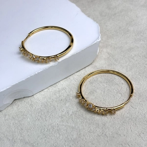 Dettaglio di orecchini a cerchio placcati oro 18K con inserti in zirconi scintillanti