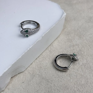 Vue détaillée des boucles d'oreilles serpent en argent avec zircons et yeux verts