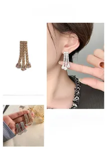 Detailed view of 18K gold plated tassel earrings with sparkling pear-cut rhinestones