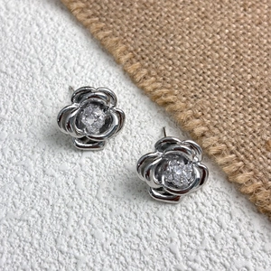 Macro detail of silver camellia earrings featuring a central sparkling 5A cubic zirconia