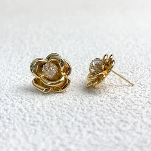 Macro shot of 18K gold plated camellia flower earrings featuring 5A zircon center stone
