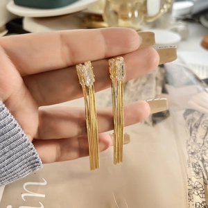 Détails de boucles d'oreilles pendantes dorées avec deux cristaux rectangulaires et chaînettes