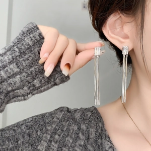 Détails de boucles d'oreilles pendantes en argent avec cristaux carrés sur un mannequin