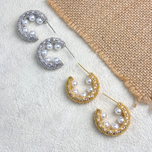 Elegant C-shaped earrings with hand-set pearls and cubic zirconia in gold and silver finish