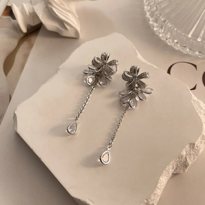Detail of silver long tassel earrings with sparkling flower cluster and drop zircon